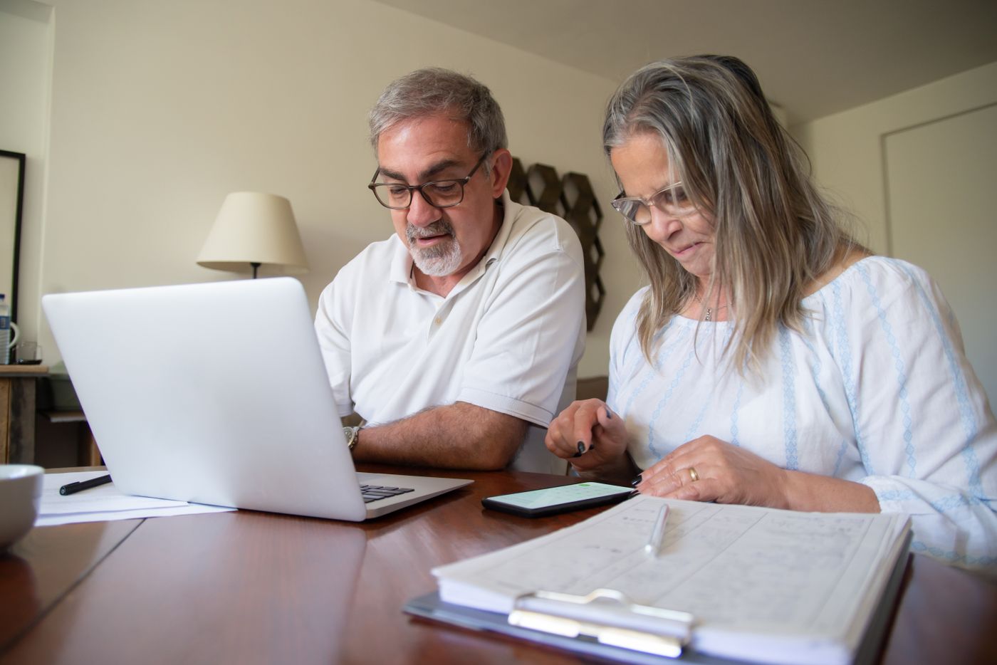Older couple reviewing financial plans at a laptop
